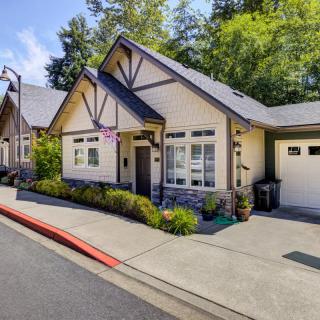 A charming cottage-style house with a garage and neatly maintained front yard.