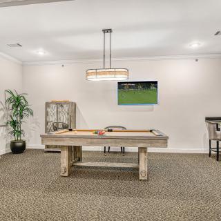 A well-designed billiard room featuring a pool table, television, and stylish decor.