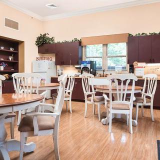 A cozy kitchen and dining area with wooden tables and chairs.