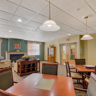 A cozy dining area with tables and chairs, featuring warm lighting and elegant decor.