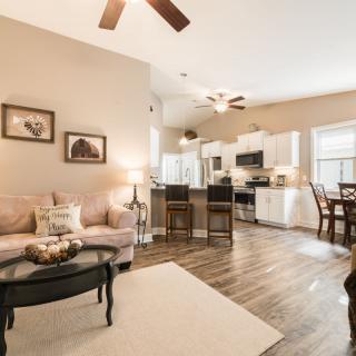 A modern open-concept living room and kitchen with hardwood floors and elegant furnishings.