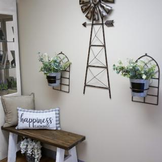 A charming country-style home decor setup featuring a decorative windmill and stylish plant holders.