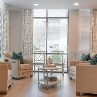 A modern living room with elegant furniture and large windows.