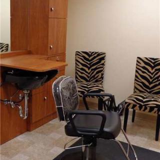 A well-organized hair salon interior featuring zebra print chairs and a styling station.