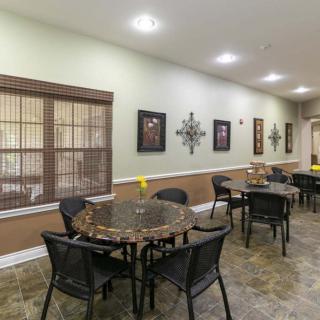 A modern dining area with tables and chairs, decorated with artwork and warm lighting.