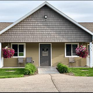A quaint residential house with hanging flower baskets and a welcoming entrance.