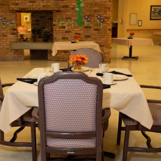 A cozy dining setup featuring a table with elegant chairs and a floral centerpiece.