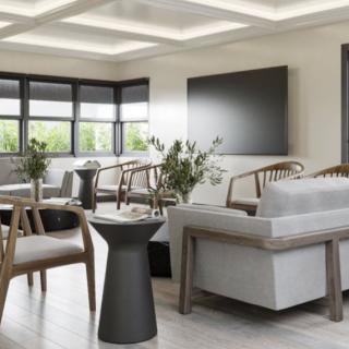 A modern and minimalist living room with stylish furniture and large windows.