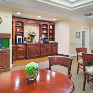 A cozy dining area with wooden cabinets and a round table decorated with a vase.