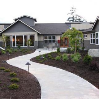 A modern house with a landscaped front yard and a winding pathway.