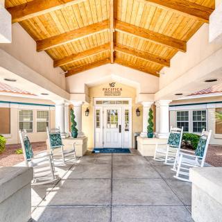 A welcoming entrance with rocking chairs under a covered walkway.