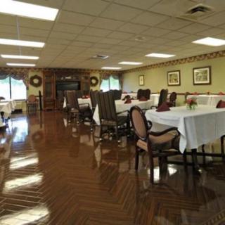 A decorated dining room with neatly arranged tables and chairs on a polished wooden floor.