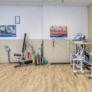 A gym interior with various fitness equipment and workout gear.