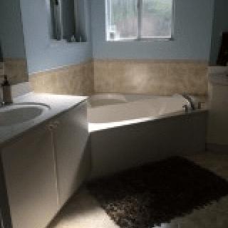 A modern bathroom interior featuring a bathtub, sink, and window.