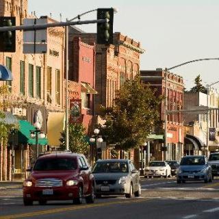 A bustling downtown street lined with historic buildings and busy with traffic.
