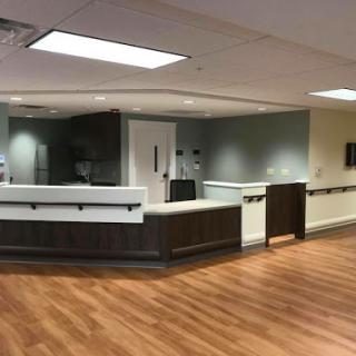 A modern reception area with a wooden floor and sleek furniture.