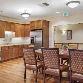 A modern kitchen and dining area with wooden cabinets and a dining table.