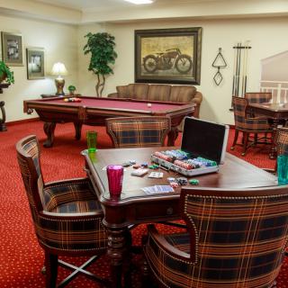 A cozy game room featuring a pool table, board games, and comfortable seating for relaxation and entertainment.