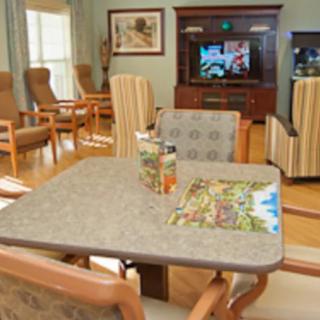 A cozy living room with comfortable chairs, a table, and a television.