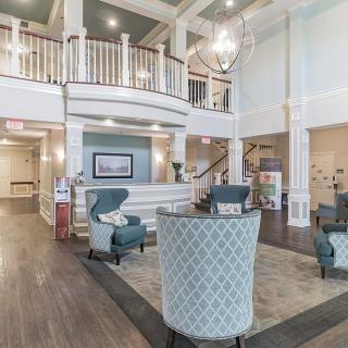 A spacious and elegantly designed lobby area with comfortable seating and a chandelier.