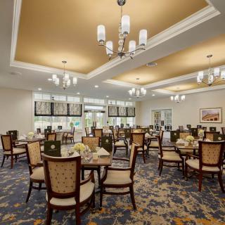 An elegantly designed dining room with chandeliers and neatly arranged tables and chairs.