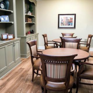 A cozy dining area with wooden tables and chairs, featuring built-in shelves for decor.
