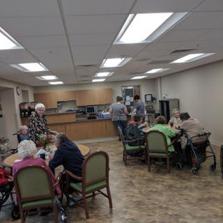 A warm and inviting dining area where seniors gather for a meal and social interaction.