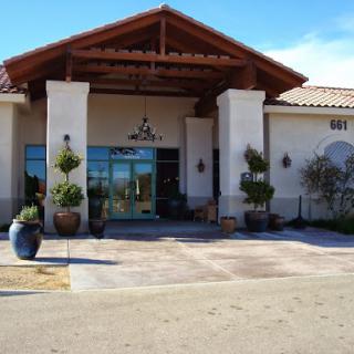 A welcoming entrance to a modern building featuring elegant architecture and thoughtful landscaping.