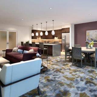 A modern open-concept living area featuring a cozy living room, kitchen, and dining space.