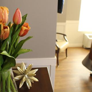 A cozy interior featuring a vase of vibrant tulips, adding a touch of nature to the stylishly decorated room.