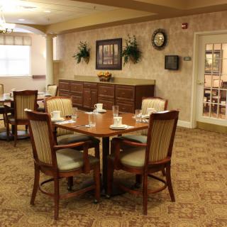 An elegant dining room with neatly arranged tables and chairs, set for a meal.