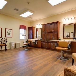 A cozy salon interior with chairs, mirrors, and wooden flooring.