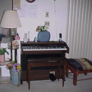 A cozy living room corner featuring an electronic piano and various decorative elements.