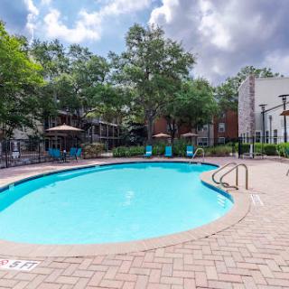 A serene residential swimming pool area surrounded by greenery, perfect for relaxation.