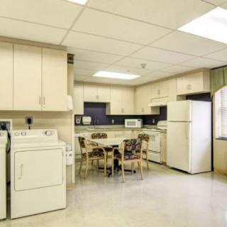 A spacious kitchen and laundry area with appliances and a dining table.