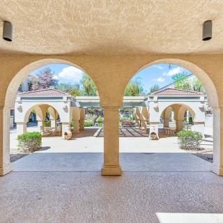 View through arched passageway to a landscaped courtyard.