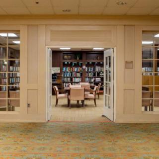 A cozy library reading area with shelves of books and comfortable seating.