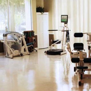 A clean and well-lit gym with various exercise equipment.