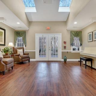 A cozy living room with wooden floors, skylights, and comfortable seating.