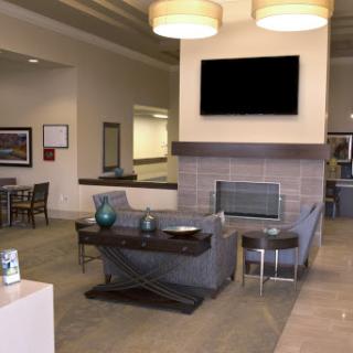 A contemporary lobby featuring a cozy seating area, fireplace, and television.