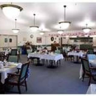 A spacious dining area with neatly arranged tables and chairs, decorated interior.