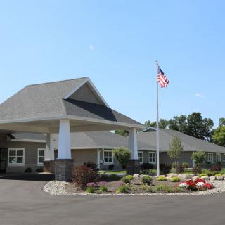 A well-maintained building with landscaped surroundings and an American flag in front.