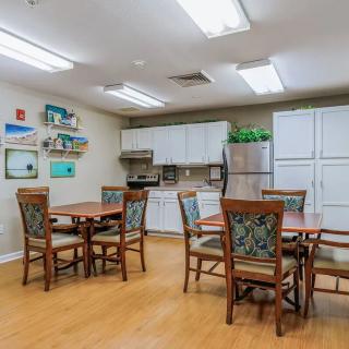 A cozy kitchen and dining area with wooden tables and chairs, featuring modern appliances and stylish decor.