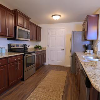 A modern kitchen with wooden cabinets and stainless steel appliances.