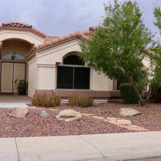 A suburban house with desert landscaping in the front yard.