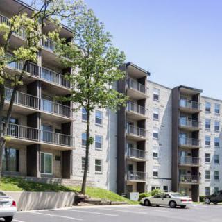 A modern apartment building with multiple floors and balconies on a sunny day.