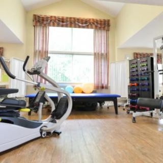 A spacious home gym featuring an elliptical machine and a variety of exercise equipment.