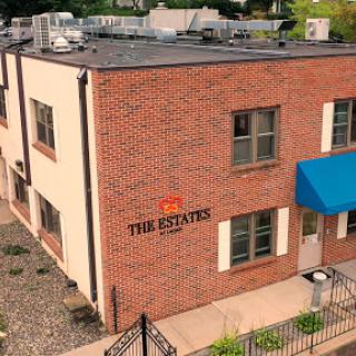 A view of 'The Estates,' showcasing its modern brick architecture and inviting entrance.