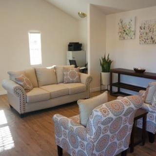 A cozy living room with a sofa, armchairs, and decorative elements.