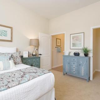 A cozy bedroom with neutral tones, featuring a large bed, stylish dresser, and elegant decor.
